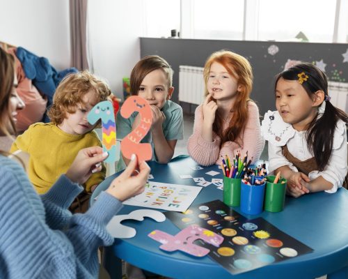 medium-shot-kids-sitting-together-table (1)