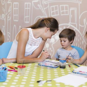 teacher-helping-kid-paint